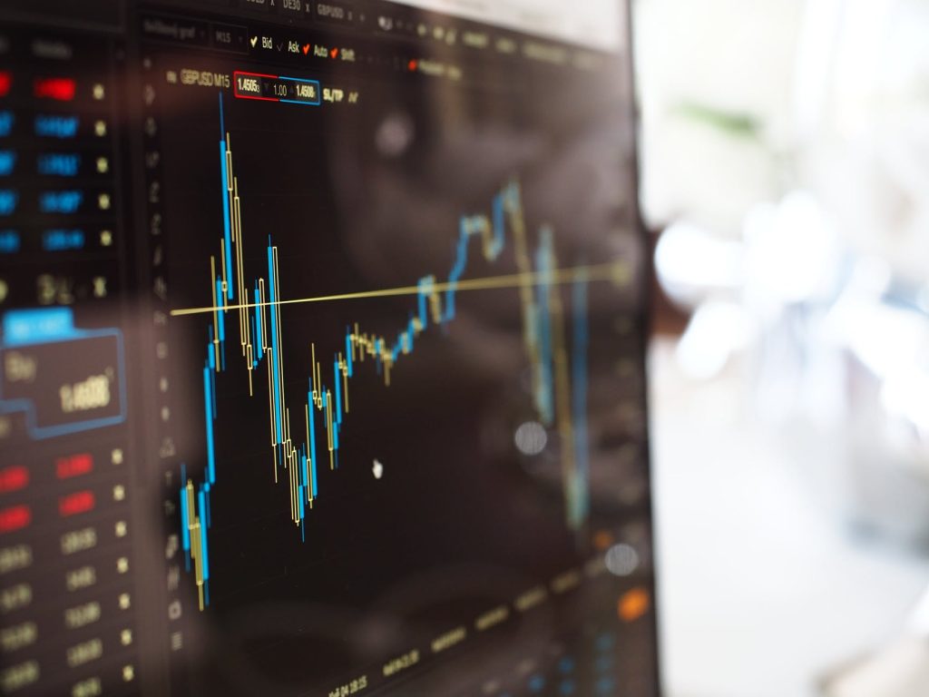 18 Easy Ways To Create Passive Income Online in 2022 - create passive income online blue and yellow graph on stock market monitor