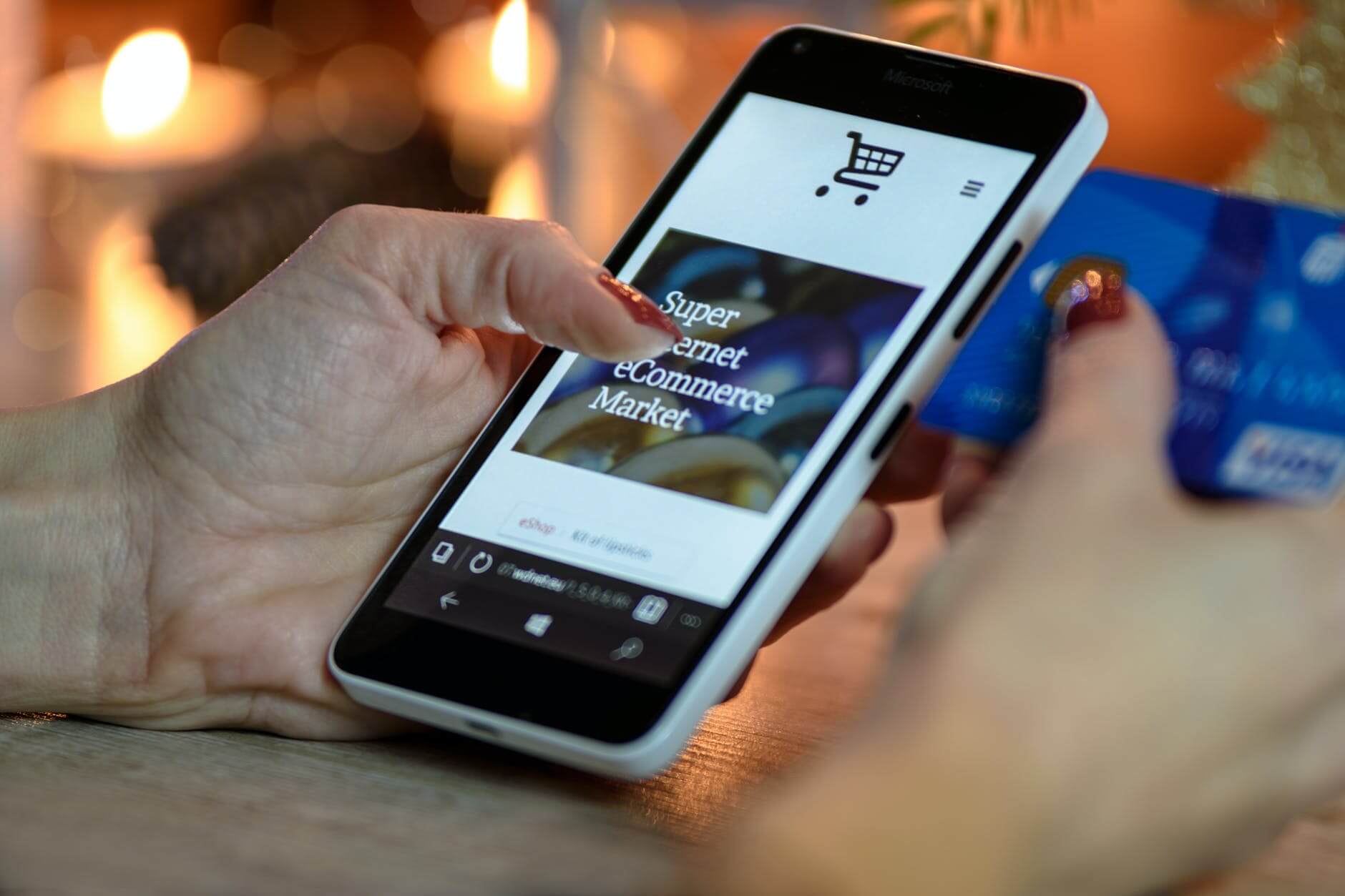 A Complete Guide To All The Online Revenue Models (2026 Update) - online revenue model person using black and white smartphone and holding blue card