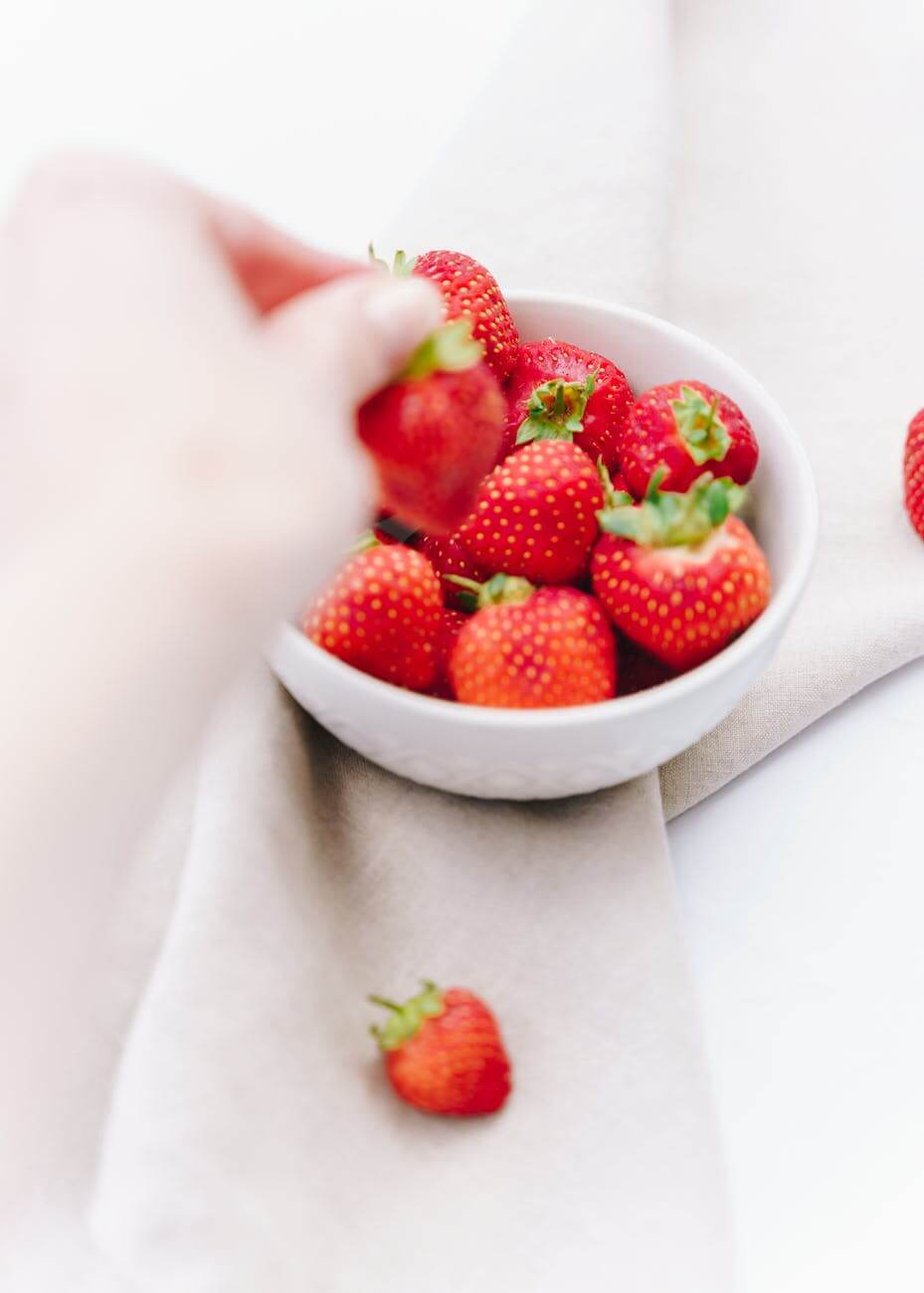 strawberries in plate on white surface